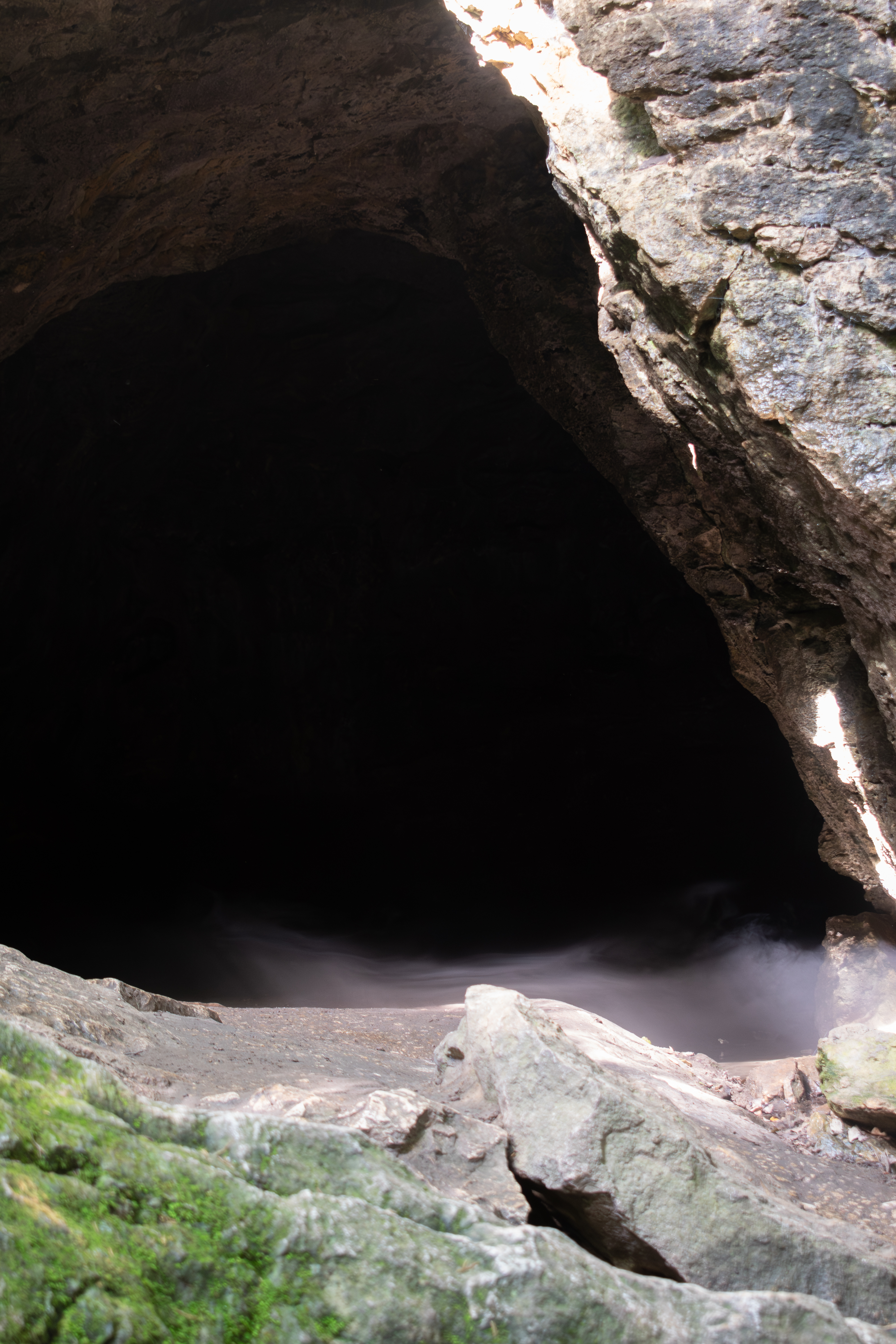 Cave entrance with mist or smoke spilling out